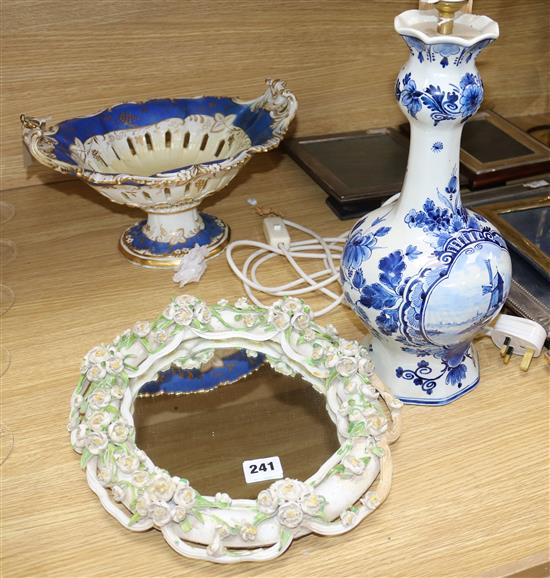 A Victorian floral encrusted wall mirror, a comport and a delft table lamp